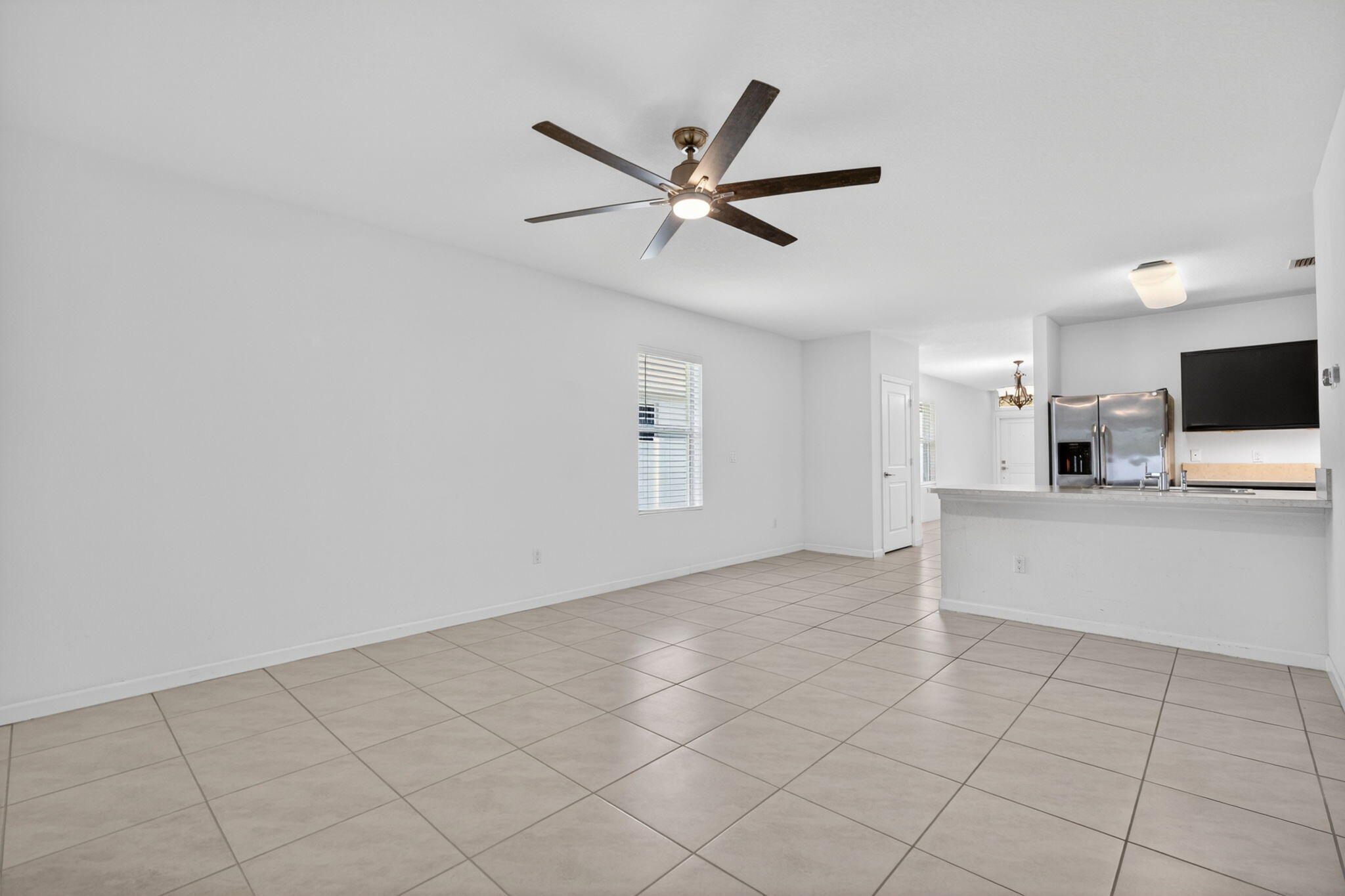 6814 Mitchell Street Jupiter, FL 33458 - Photo 25 of 49 a view of a livingroom with a ceiling fan and wooden floor