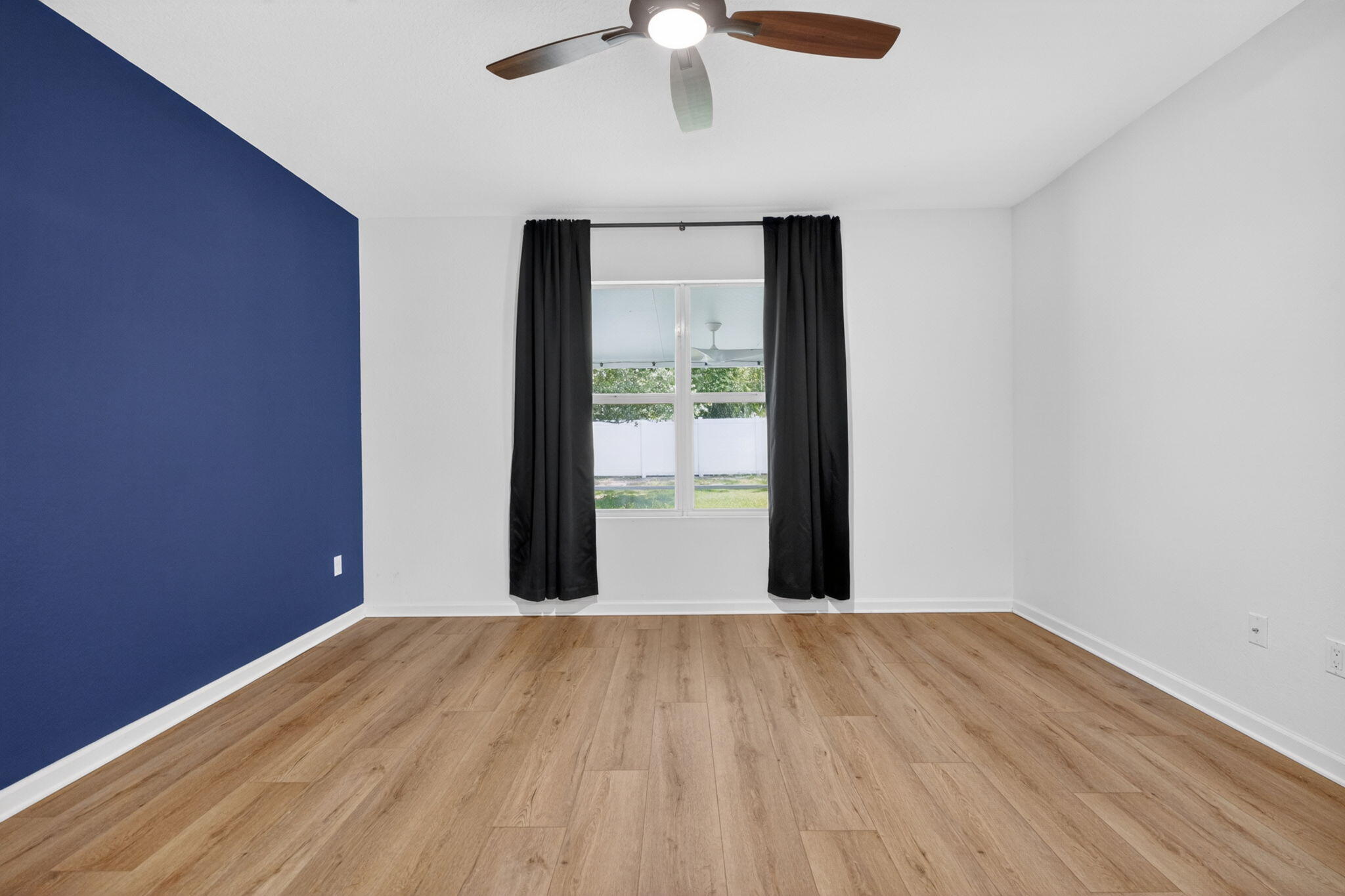 6814 Mitchell Street Jupiter, FL 33458 - Photo 28 of 49 a view of an empty room with wooden floor and a window