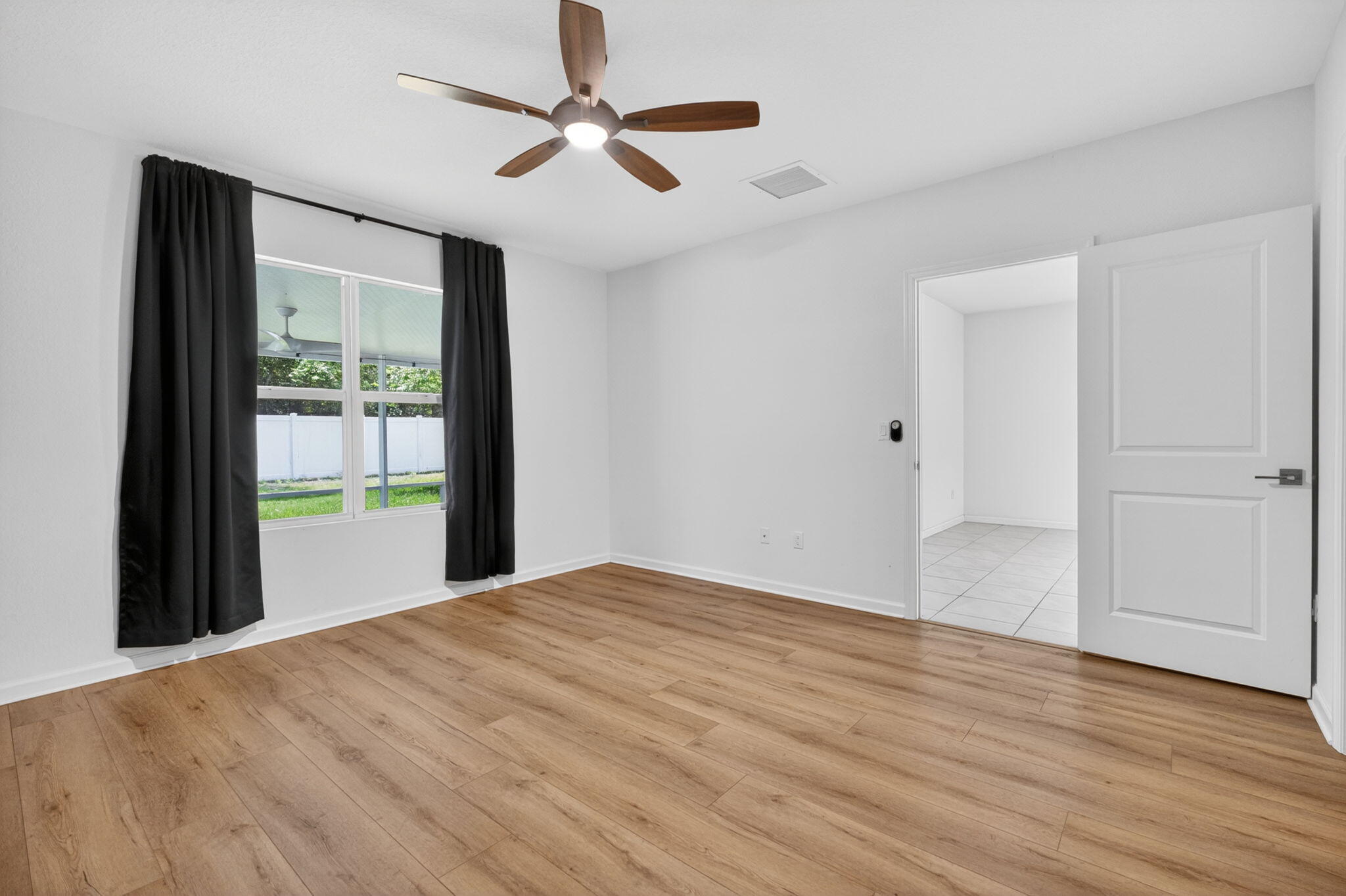6814 Mitchell Street Jupiter, FL 33458 - Photo 29 of 49 a view of an empty room with wooden floor and a window