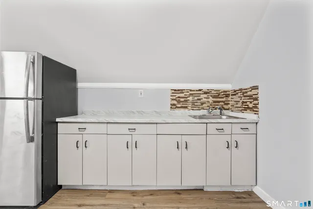 a view of kitchen with wooden floor electronic appliances and wooden floor