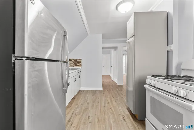 a kitchen with a refrigerator and a stove top oven