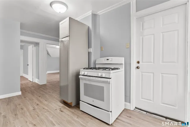 a kitchen with stainless steel appliances white cabinets and wooden floors