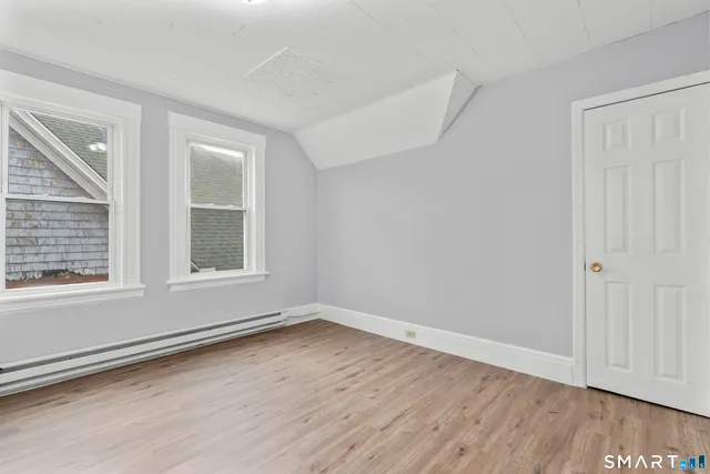 a view of an empty room with wooden floor