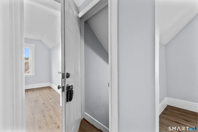 a view of a hallway with wooden floor and closet