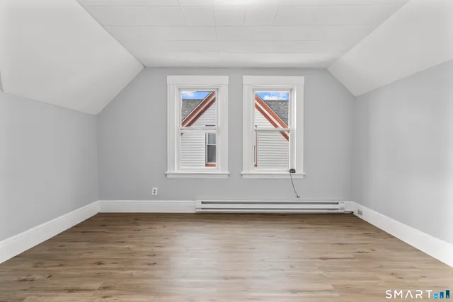 a view of an empty room with wooden floor