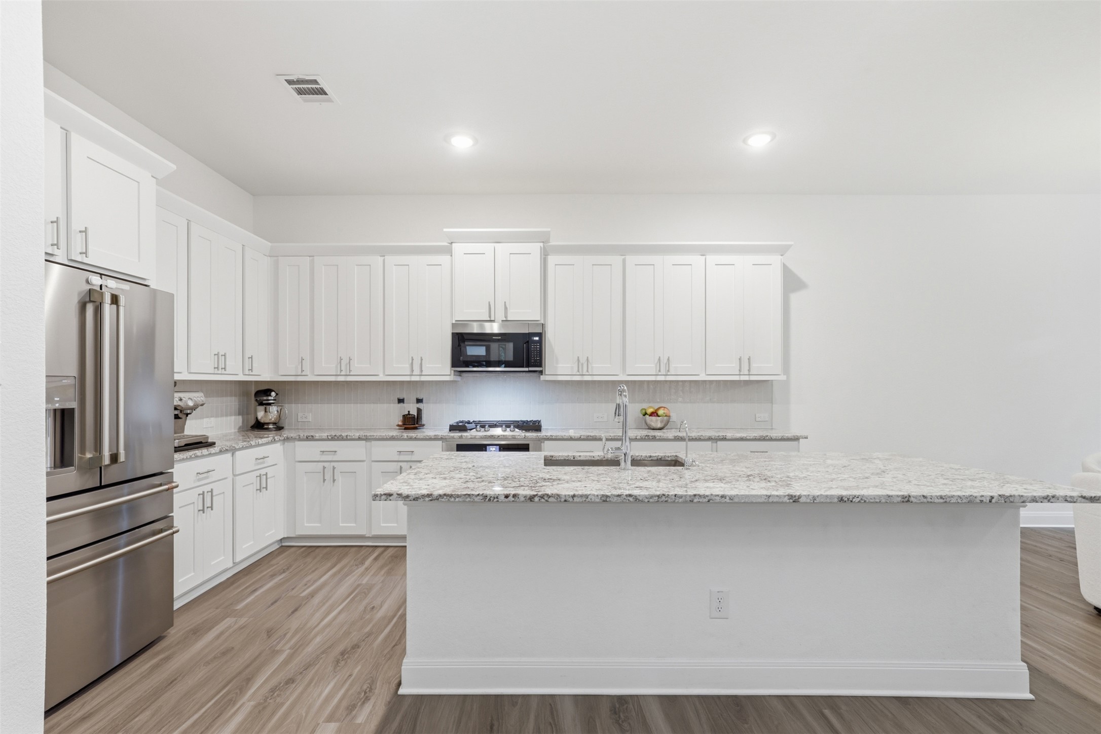 3021 Sage Ranch Drive Leander, TX 78641 - Photo 10 of 32 a kitchen with stainless steel appliances granite countertop a stove a sink and a refrigerator