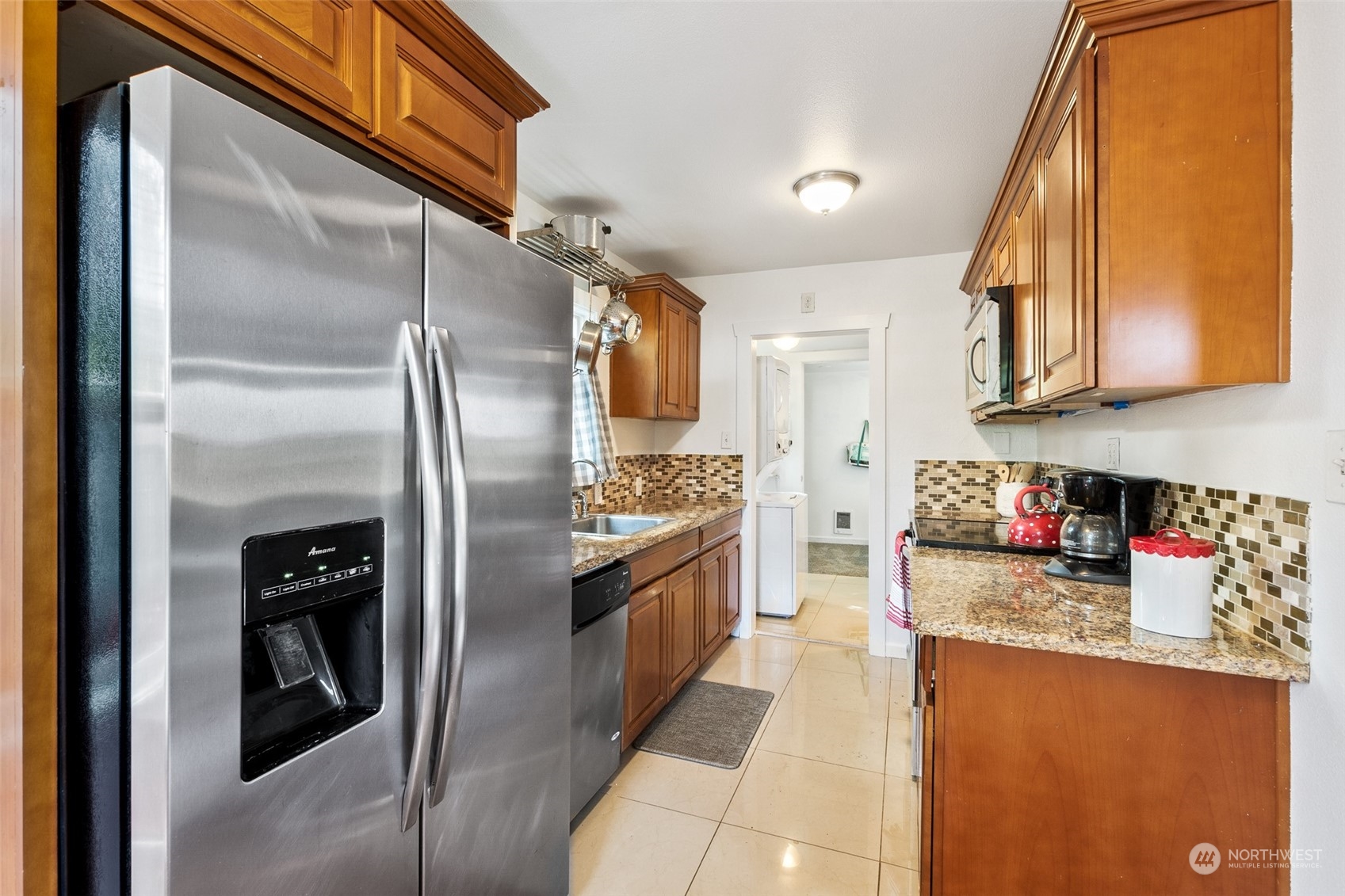 1031 Southwest 118th Street Seattle, WA 98146 - Photo 5 of 16 a kitchen with stainless steel appliances granite countertop a refrigerator a stove and a sink