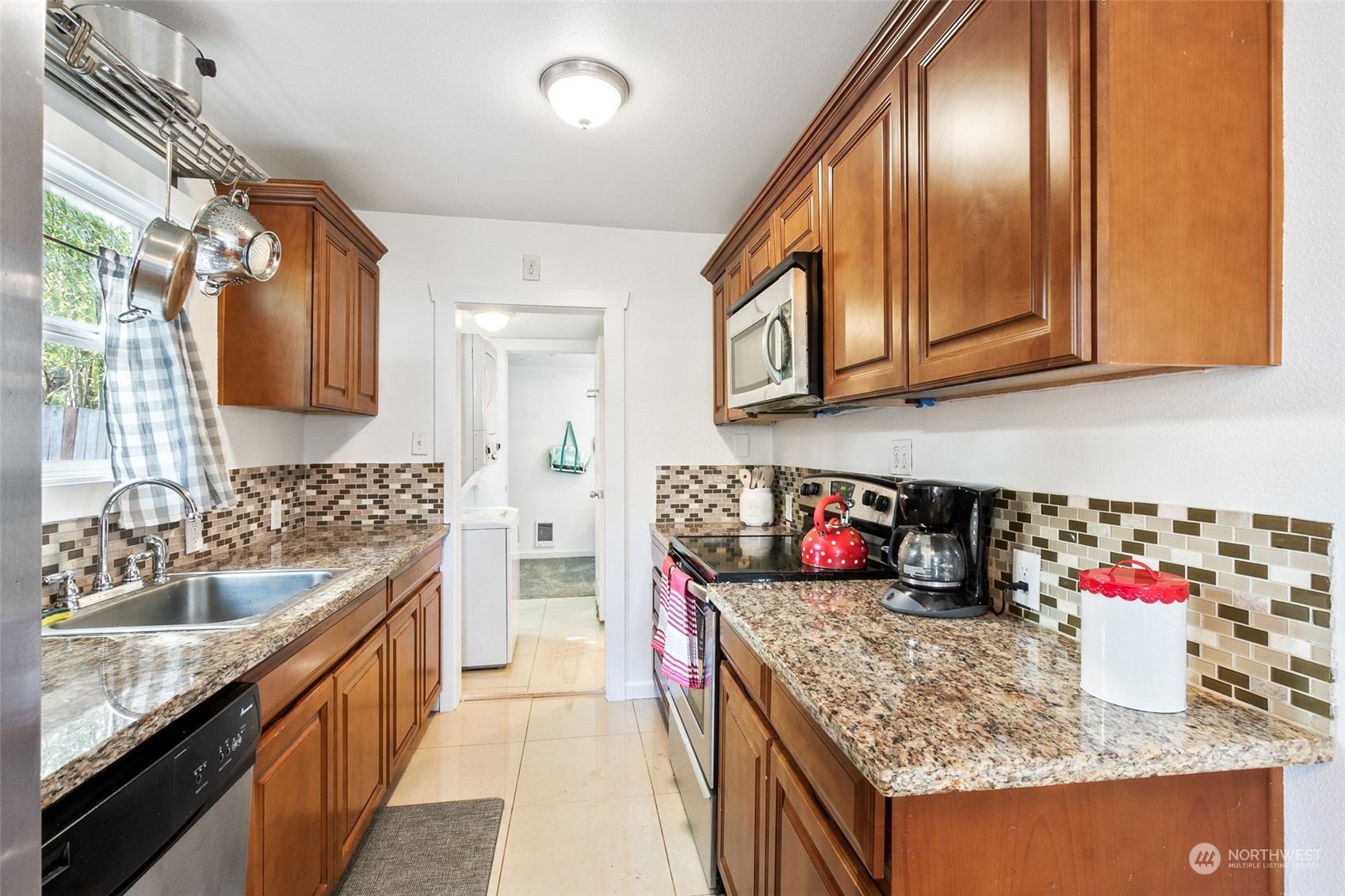 1031 Southwest 118th Street Seattle, WA 98146 - Photo 8 of 16 a kitchen with granite countertop stainless steel appliances a sink dishwasher refrigerator stove and cabinets