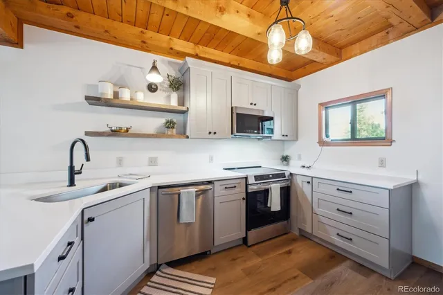 a kitchen with cabinets appliances a sink and a window