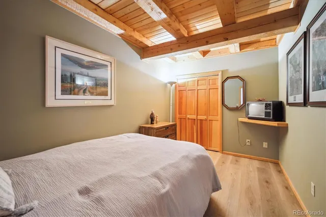 a bedroom with a bed and a large mirror on the dresser