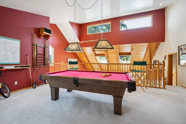 a room with pool table and windows