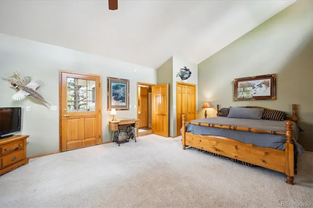 a spacious bedroom with a bed and a painting on the wall