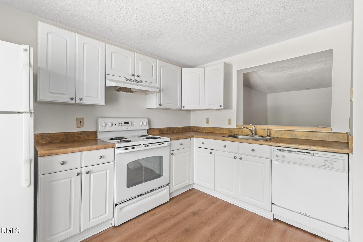 1135 Villa Green Court Raleigh, NC 27612 - Photo 5 of 17 a kitchen with white cabinets sink and stainless steel appliances