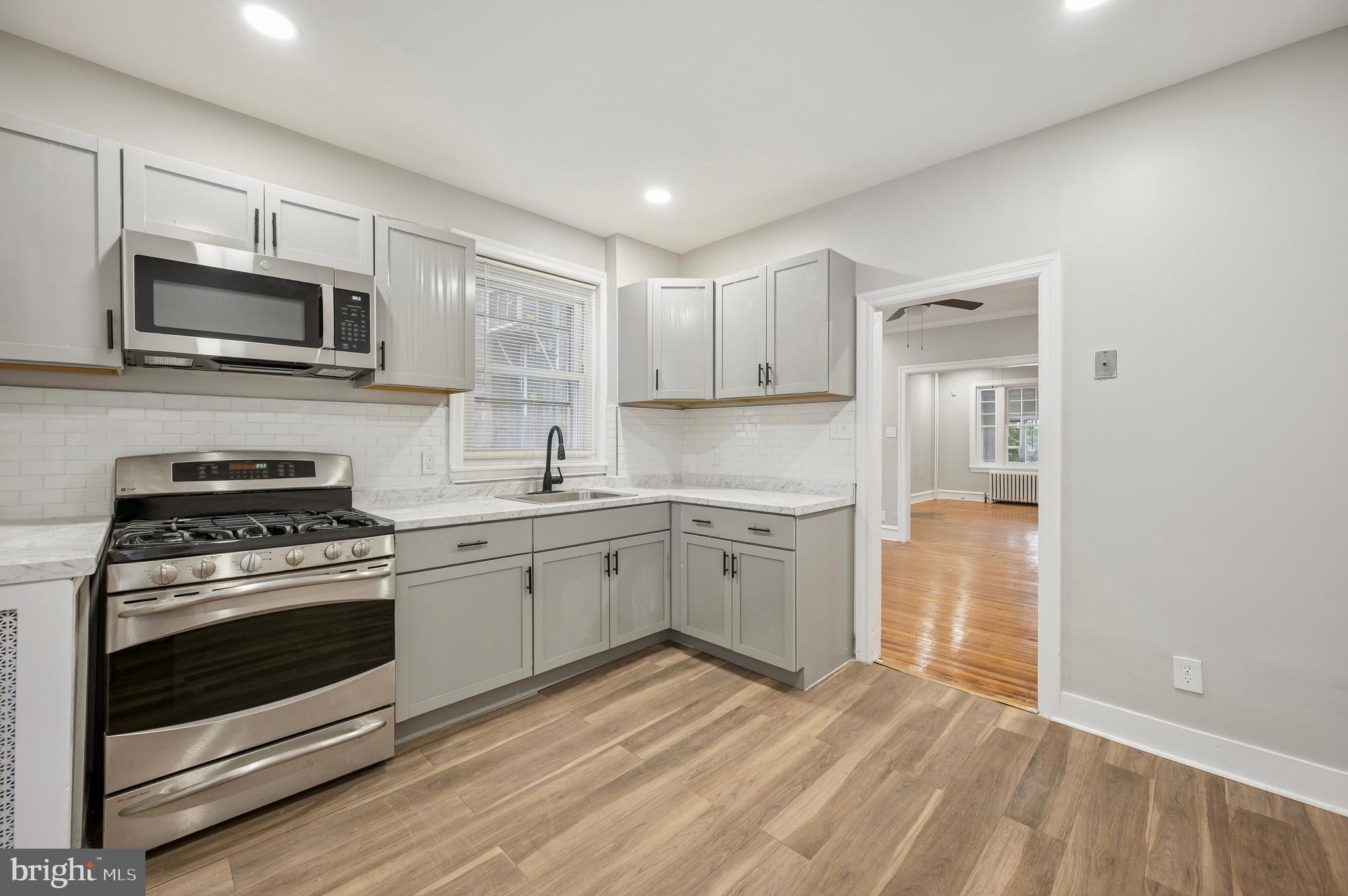 5625 Willows Avenue Philadelphia, PA 19143 - Photo 6 of 15 a kitchen with a stove a sink and a microwave