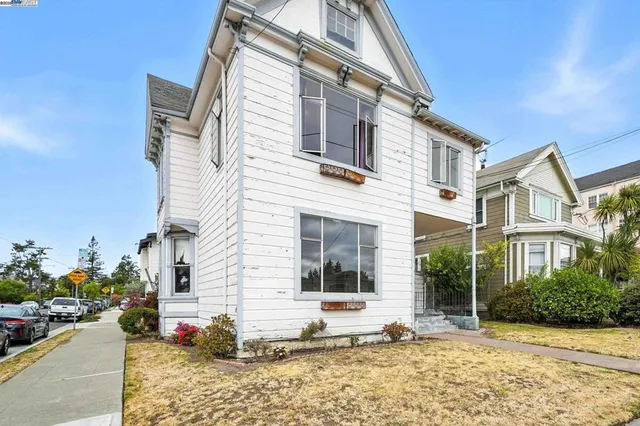 a view of a white house with a potted plant and a large window