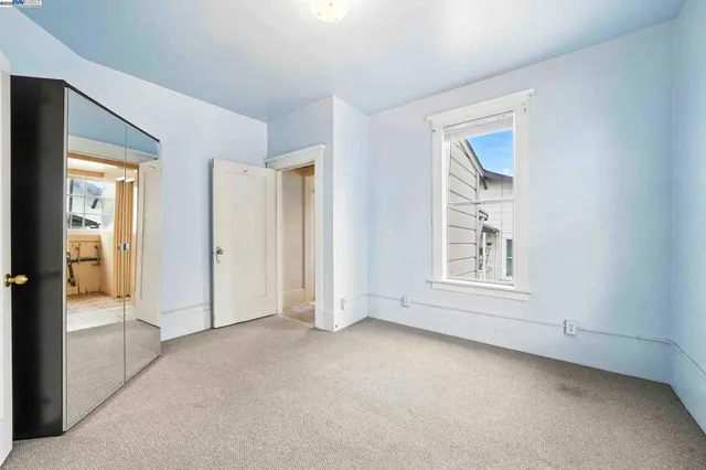 an empty room with windows and closet