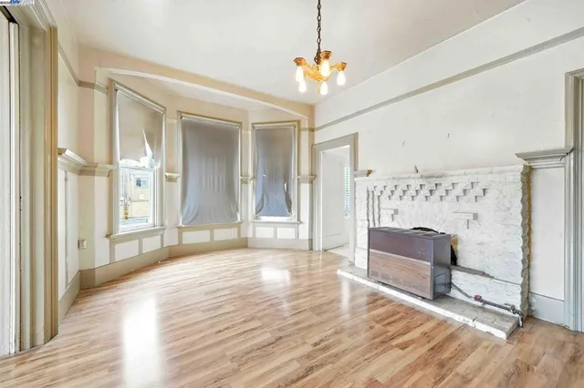 a view of a livingroom with wooden floor and a chandelier