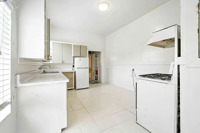 a kitchen with white cabinets and white appliances
