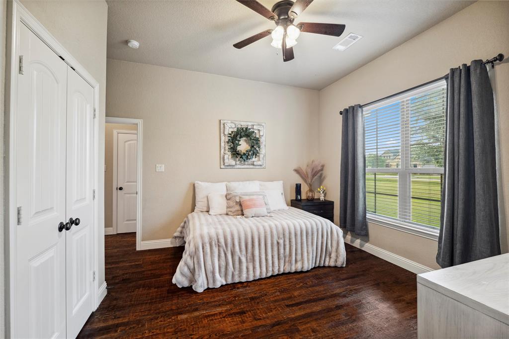 112 Shepherds Hill Road Waxahachie, TX 75165 - Photo 20 of 38 a bedroom with a large bed and a chandelier