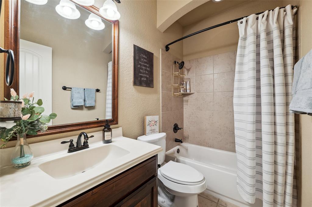 112 Shepherds Hill Road Waxahachie, TX 75165 - Photo 22 of 38 a bathroom with a sink a toilet a mirror a vanity and shower