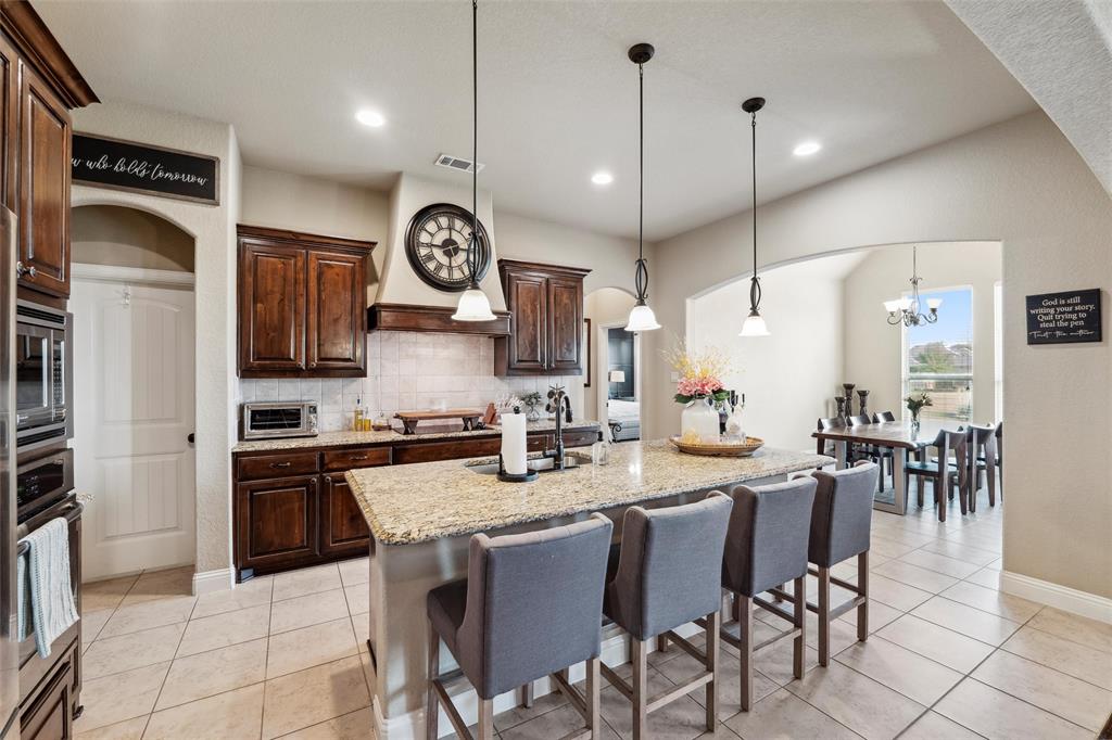 112 Shepherds Hill Road Waxahachie, TX 75165 - Photo 8 of 38 a kitchen with stainless steel appliances granite countertop a stove a sink a dining table and chairs