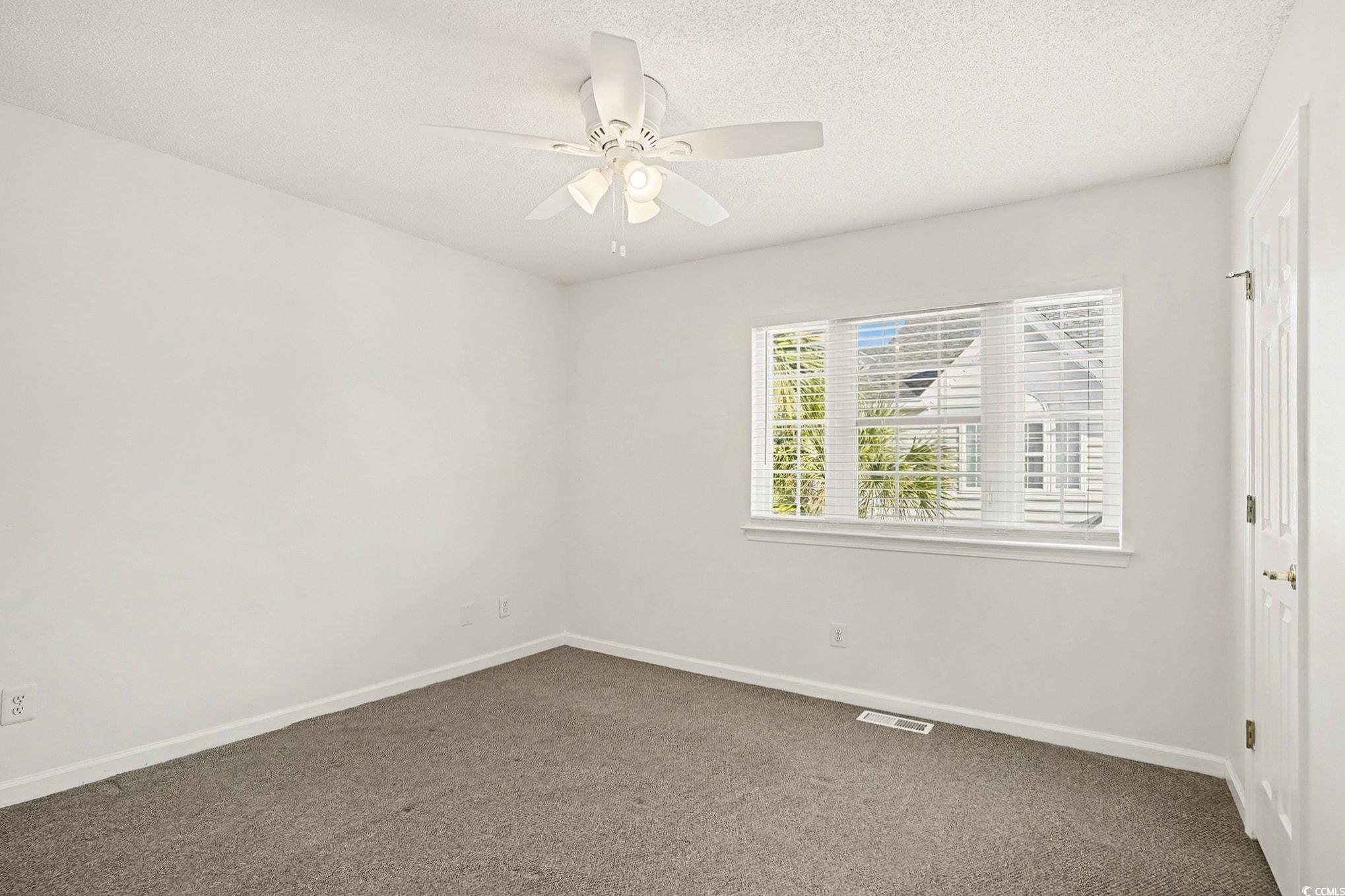 609 Sailbrooke Court, Unit 105 Murrells Inlet, SC 29576 - Photo 14 of 23 Carpeted spare room featuring a textured ceiling and ceiling fan