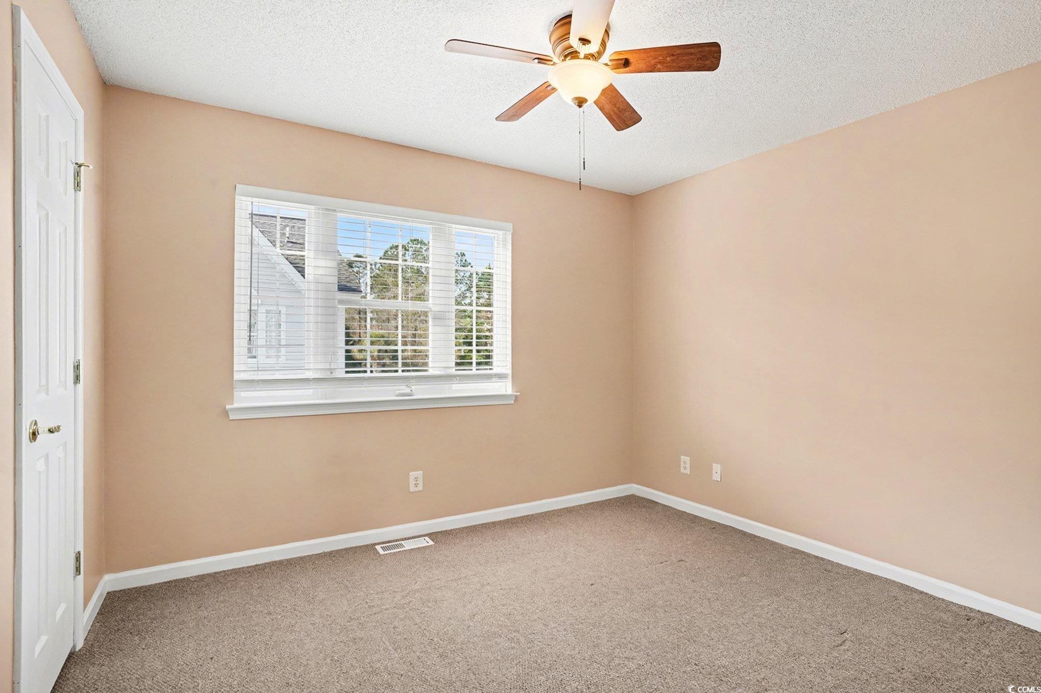609 Sailbrooke Court, Unit 105 Murrells Inlet, SC 29576 - Photo 17 of 23 Unfurnished bedroom with light carpet, ceiling fan, and a textured ceiling