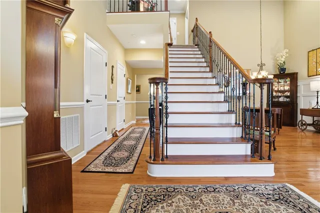 a view of a hallway with wooden floor and staircase