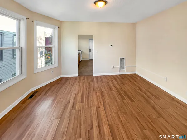 a view of a room with wooden floor and windows