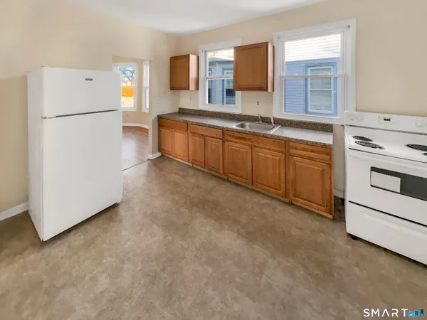 a kitchen with a refrigerator sink and white cabinets