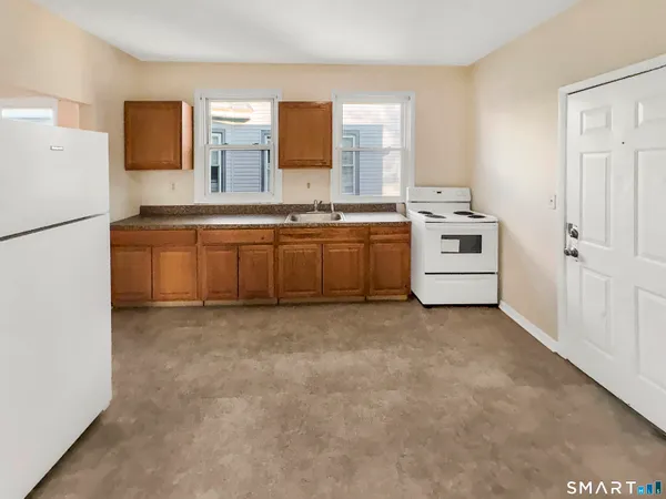a large white kitchen with a sink stainless steel appliances and cabinets