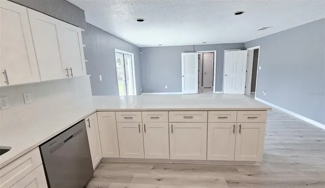a kitchen with granite countertop a refrigerator and a stove top oven