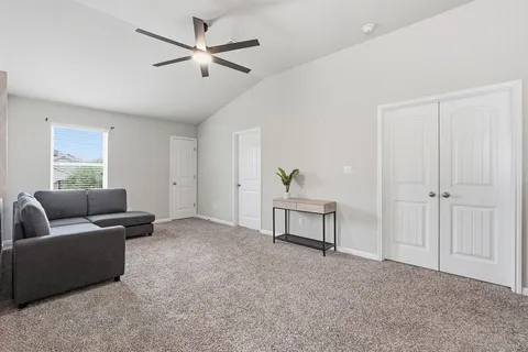 a living room with furniture and a ceiling fan