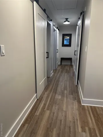 a view of a hallway with wooden floor and staircase