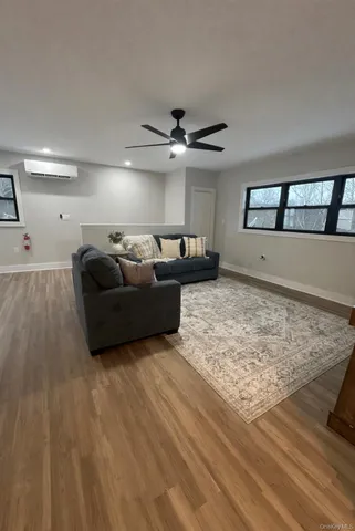 a living room with furniture and a ceiling fan