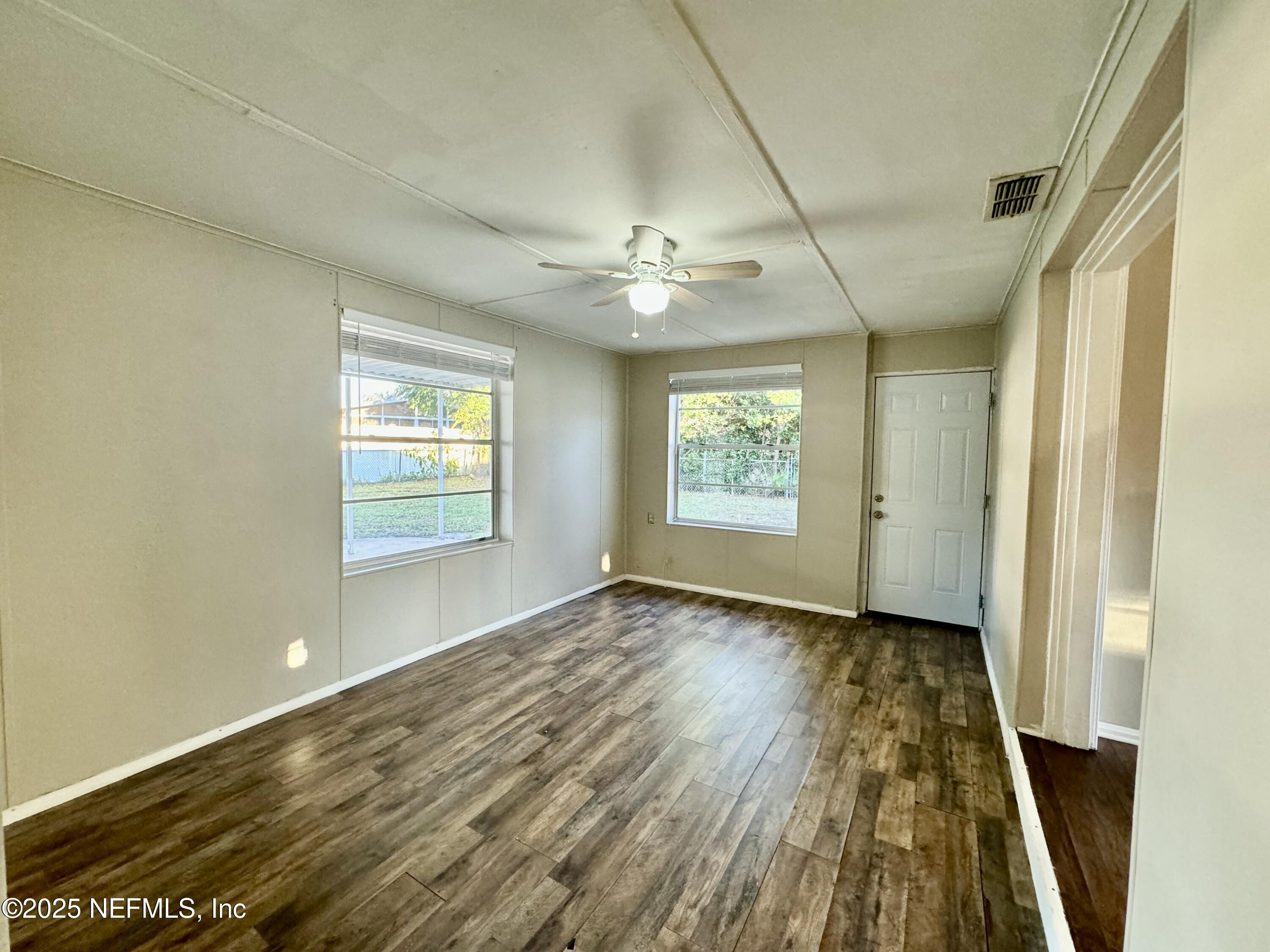 1157 Gunka Road Jacksonville, FL 32216 - Photo 13 of 24 a view of an empty room with a window and wooden floor