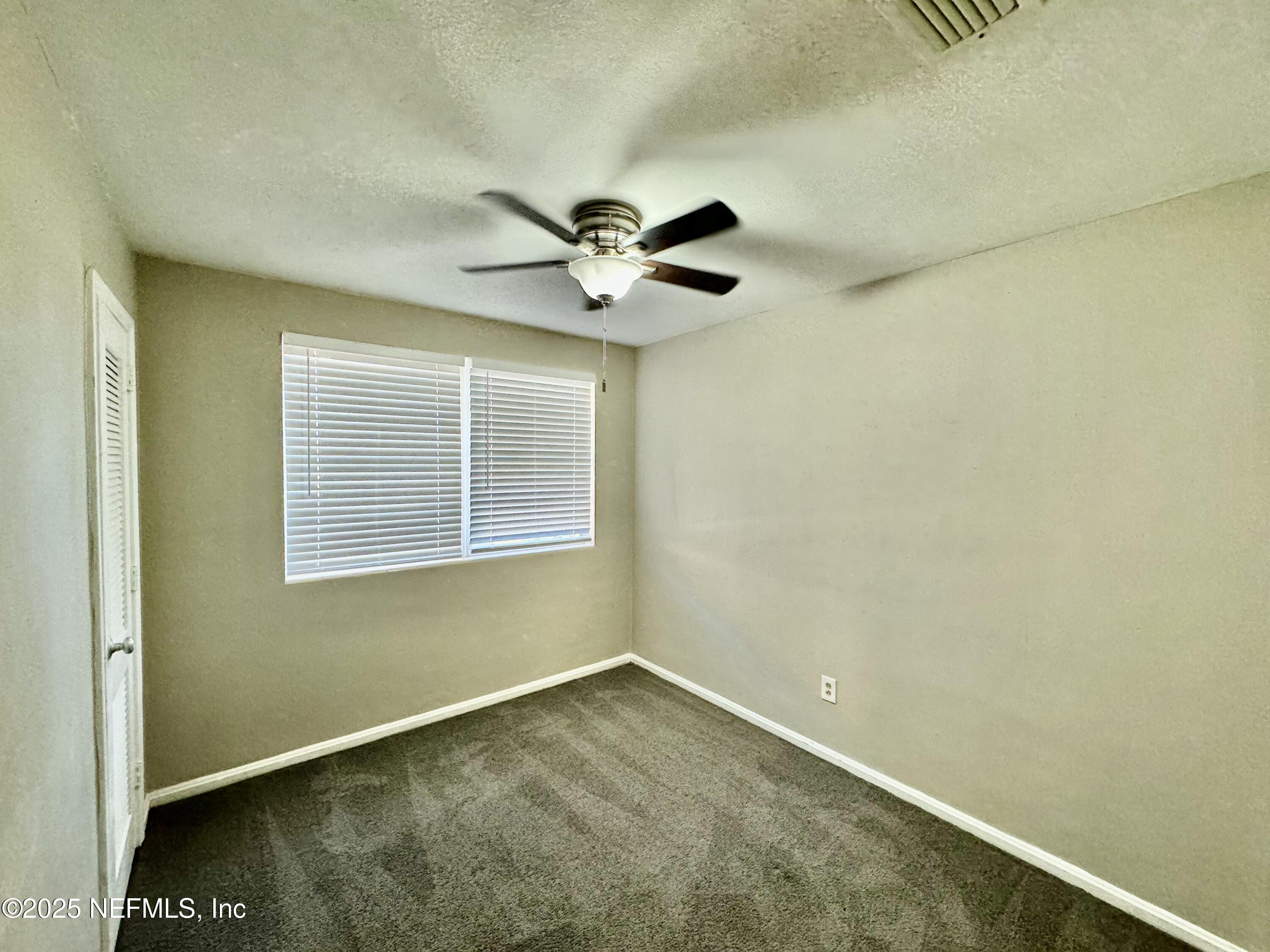 1157 Gunka Road Jacksonville, FL 32216 - Photo 15 of 24 an empty room with ceiling fan and window