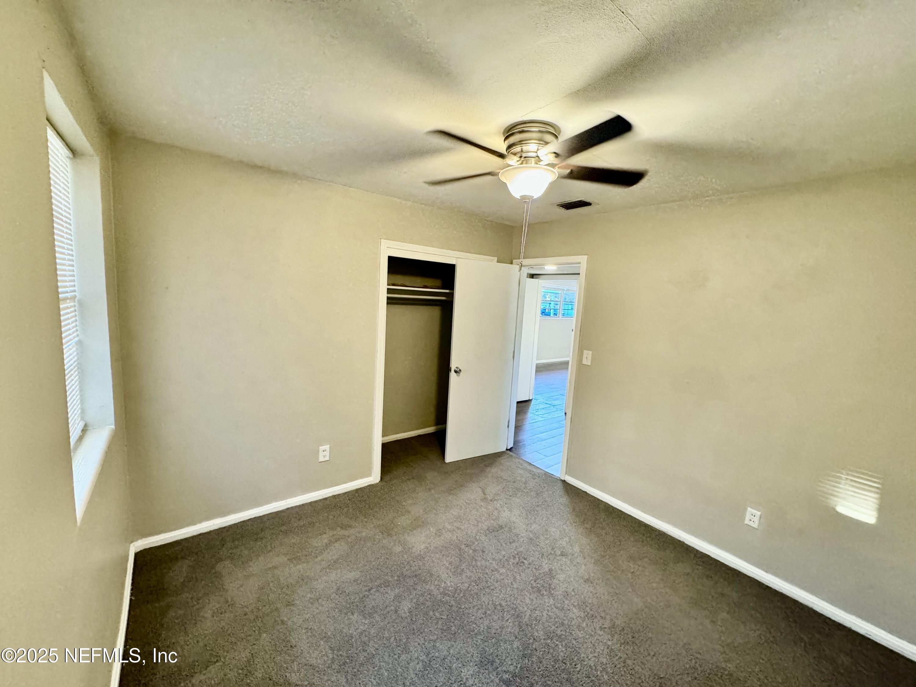 1157 Gunka Road Jacksonville, FL 32216 - Photo 17 of 24 a view of an empty room and a ceiling fan