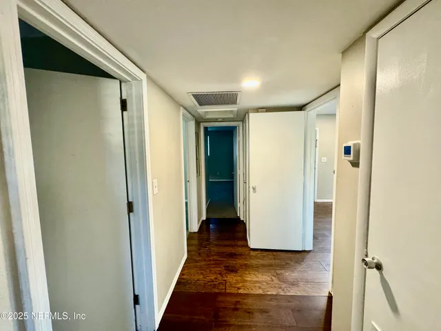 a view of a hallway with wooden floor and closet