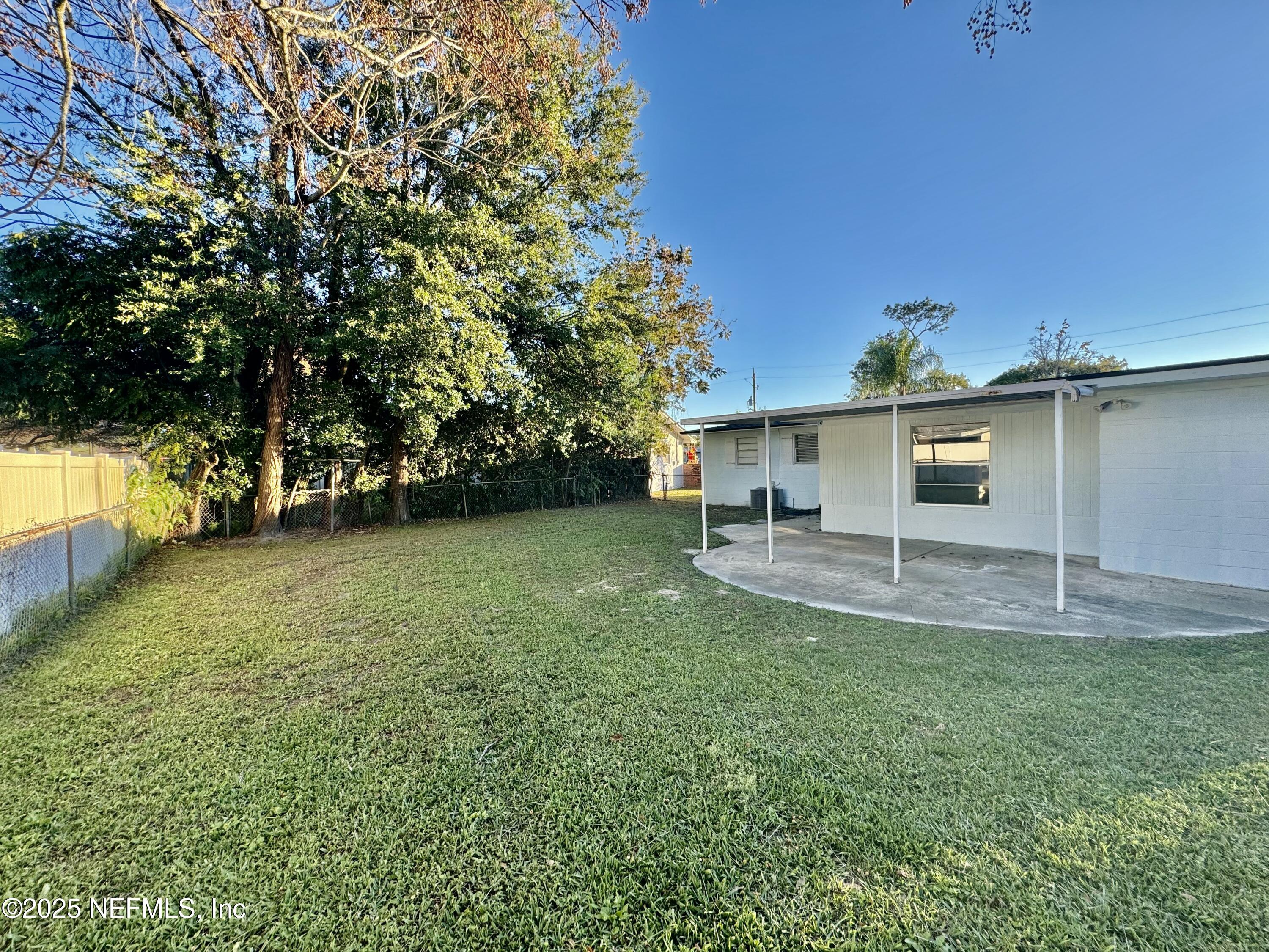 1157 Gunka Road Jacksonville, FL 32216 - Photo 22 of 24 a backyard of a house with plants and large tree