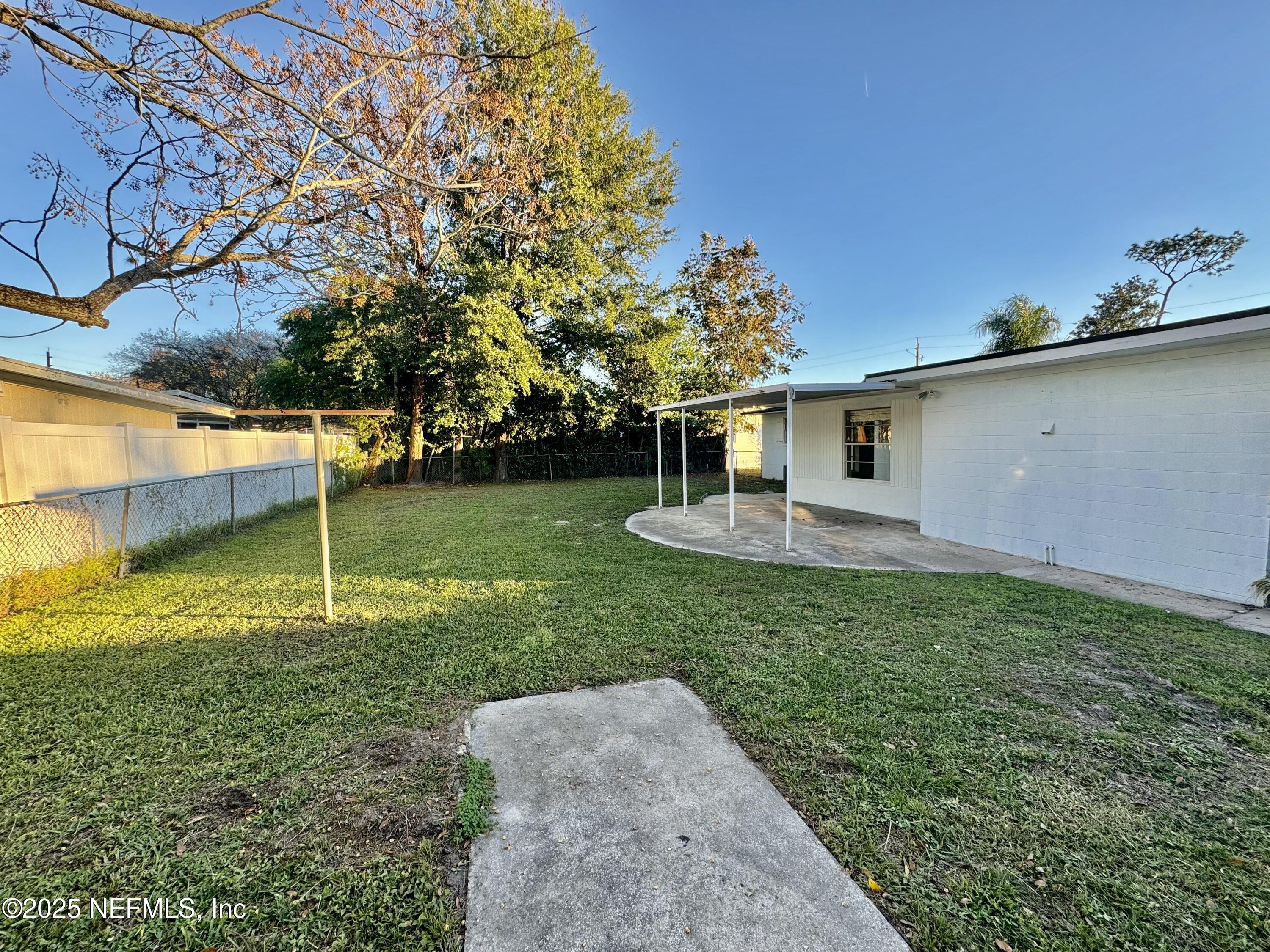 1157 Gunka Road Jacksonville, FL 32216 - Photo 23 of 24 a backyard of a house with lots of green space