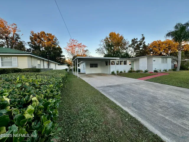 a front view of a house with a yard and trees