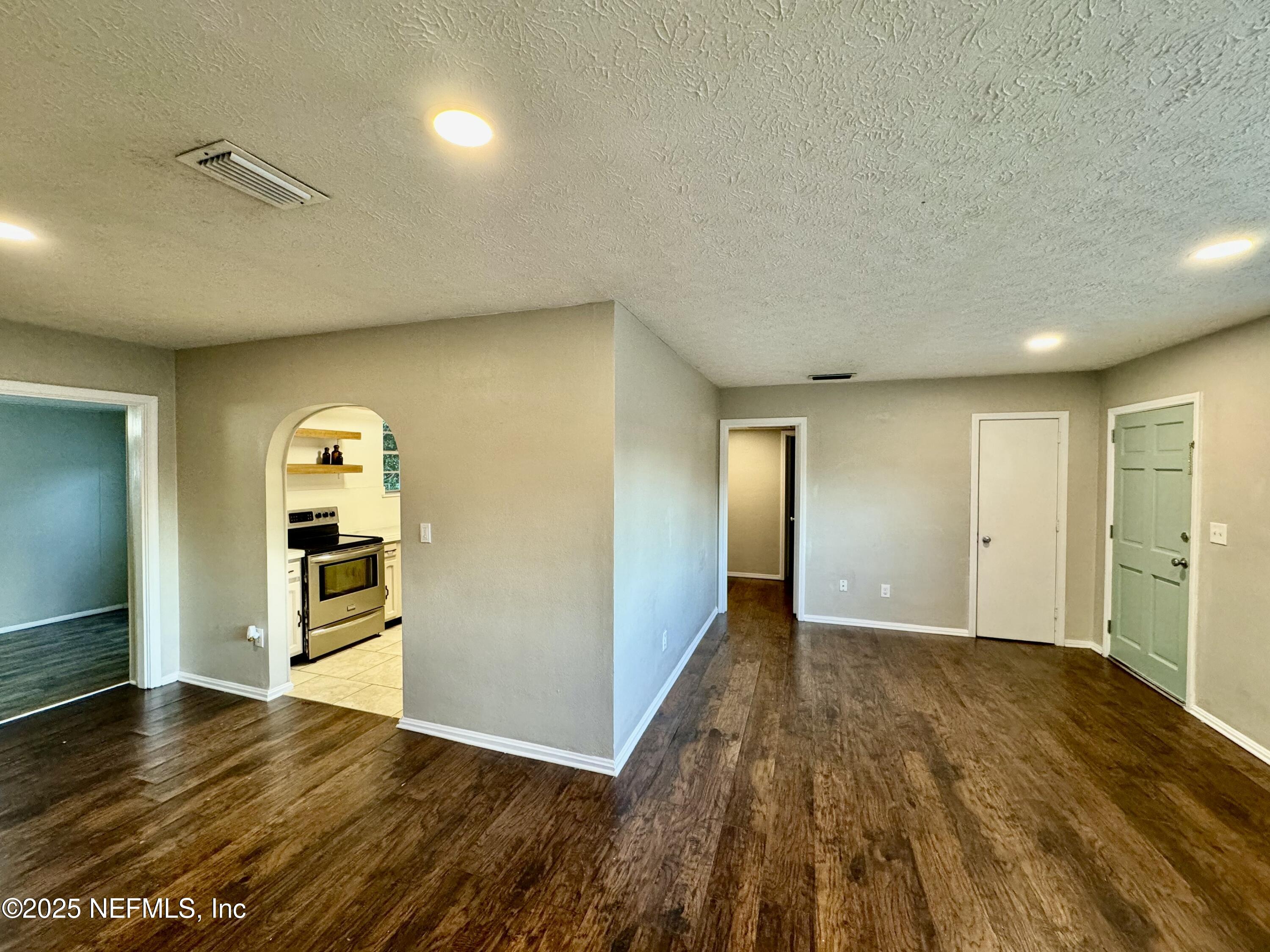 1157 Gunka Road Jacksonville, FL 32216 - Photo 5 of 24 an empty room with wooden floor and mirror