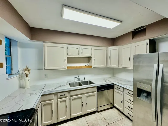 a kitchen with stainless steel appliances granite countertop a sink refrigerator and cabinets