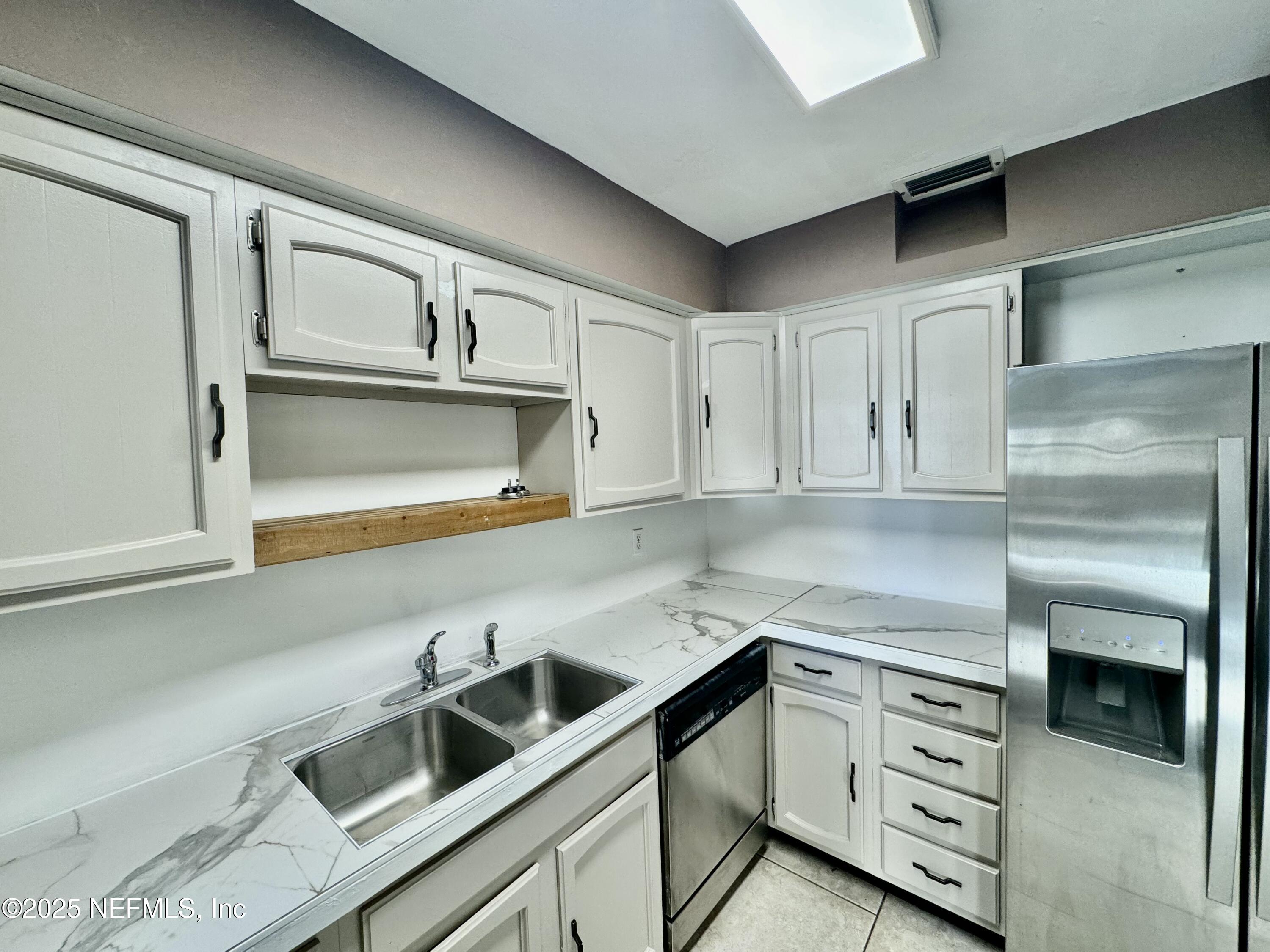 1157 Gunka Road Jacksonville, FL 32216 - Photo 9 of 24 a kitchen with cabinets stainless steel appliances and a window