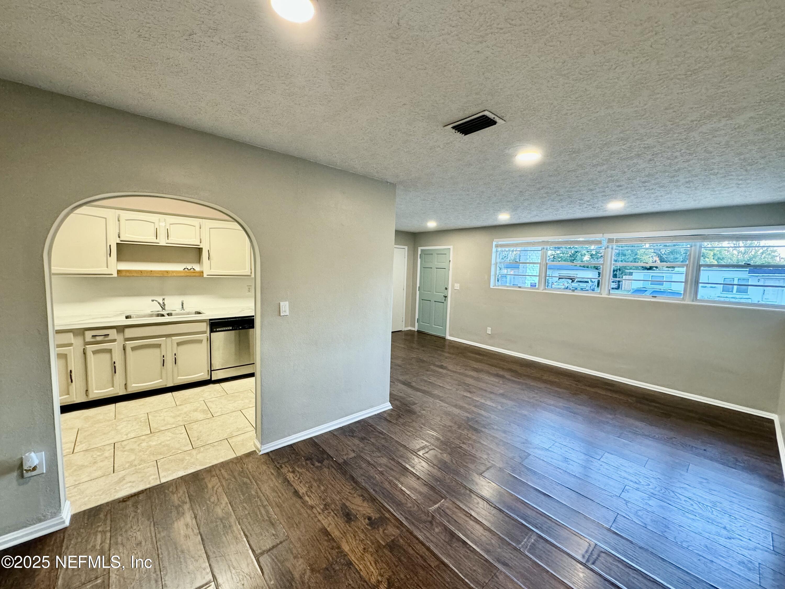 1157 Gunka Road Jacksonville, FL 32216 - Photo 10 of 24 a view of empty room with kitchen and wooden floor