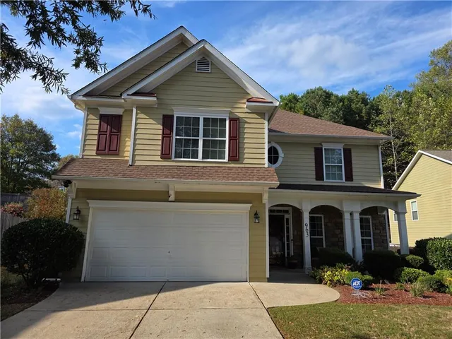 a front view of a house with yard and potted plants