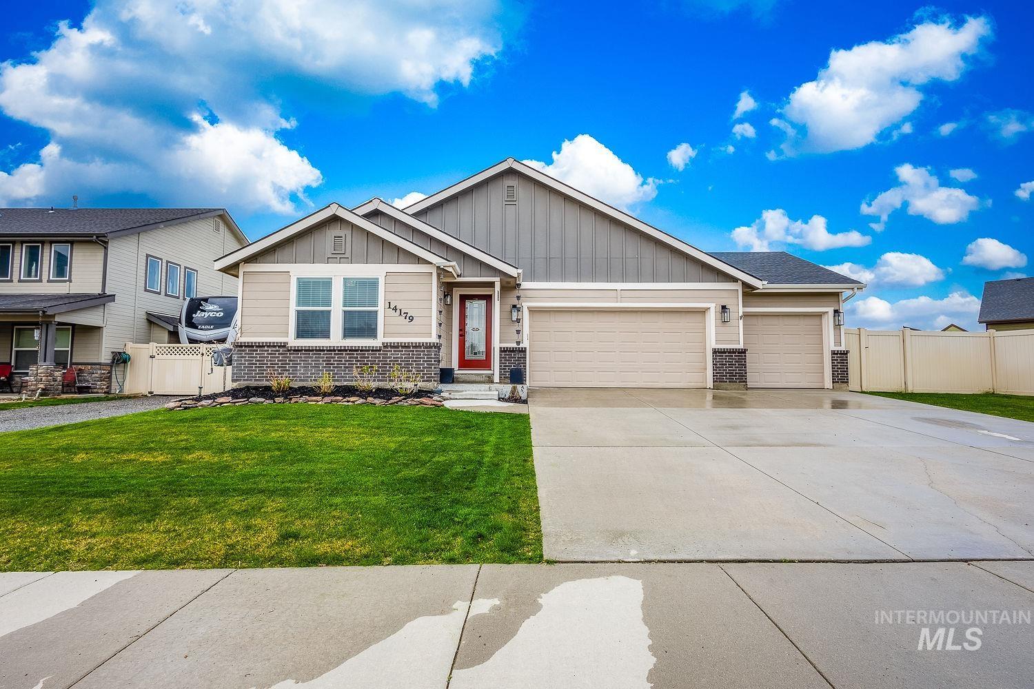 14179 Silver Lining Drive Caldwell, ID 83607 - Photo 1 of 1 Craftsman-style home with board and batten siding, an attached garage, brick siding, driveway, and a gate