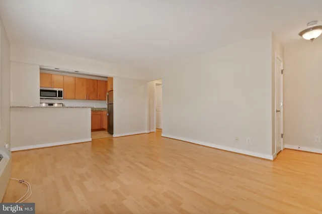 a view of a kitchen with a sink stove cabinets and empty room
