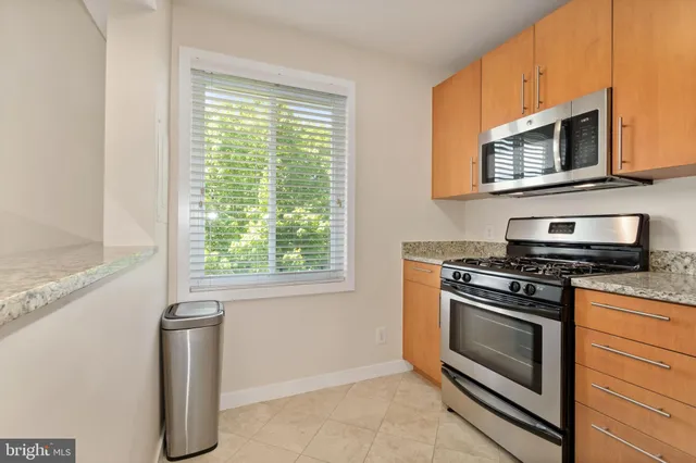 a kitchen with stainless steel appliances a stove microwave and sink
